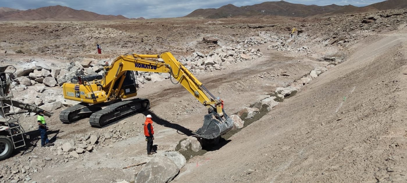 Excavadora en foso ancho con trabajadores cerca, faena Ara-Chile