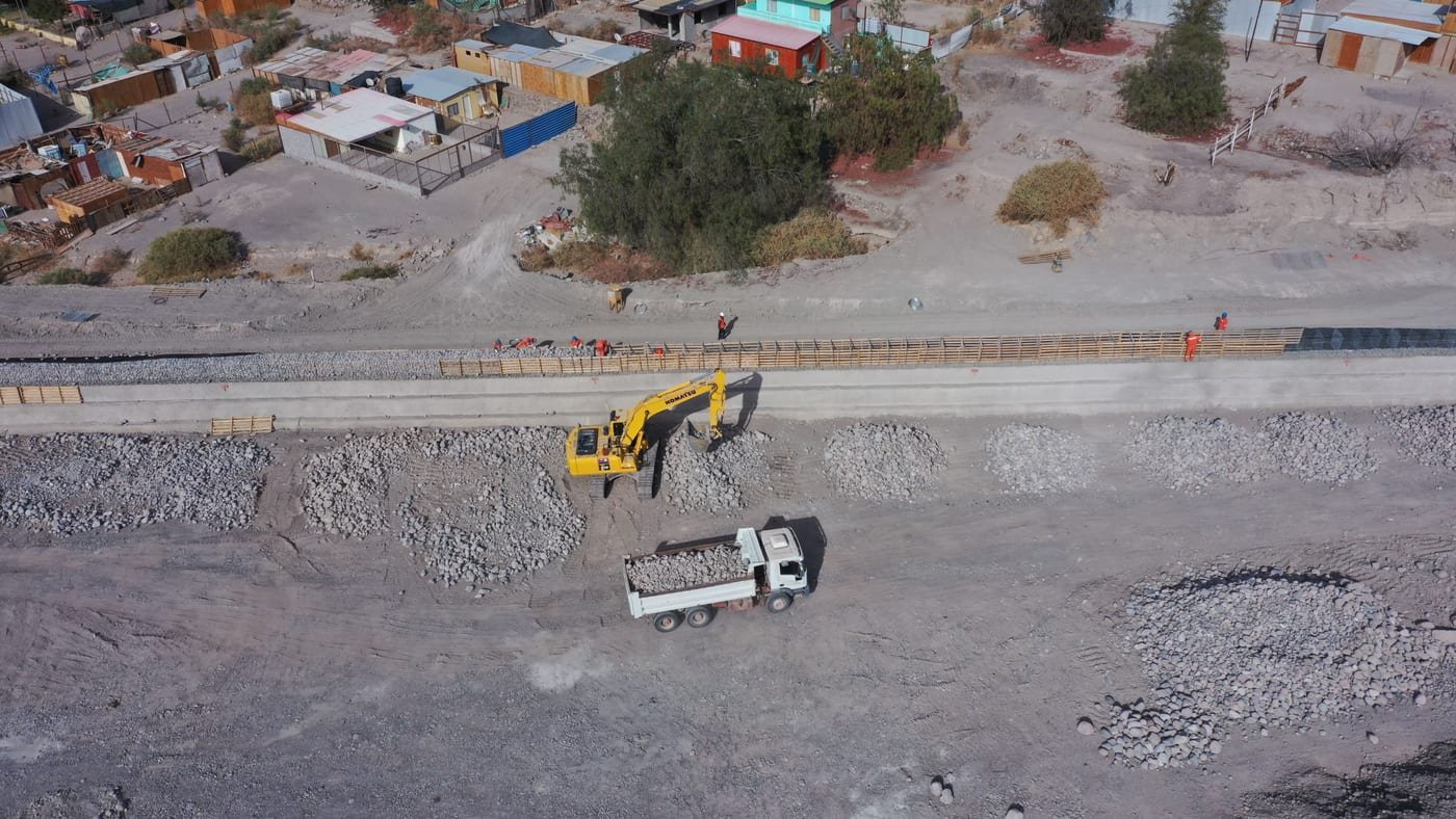 Vista cenital de vehículo y trabajadores junto a zanja, faena sanitaria